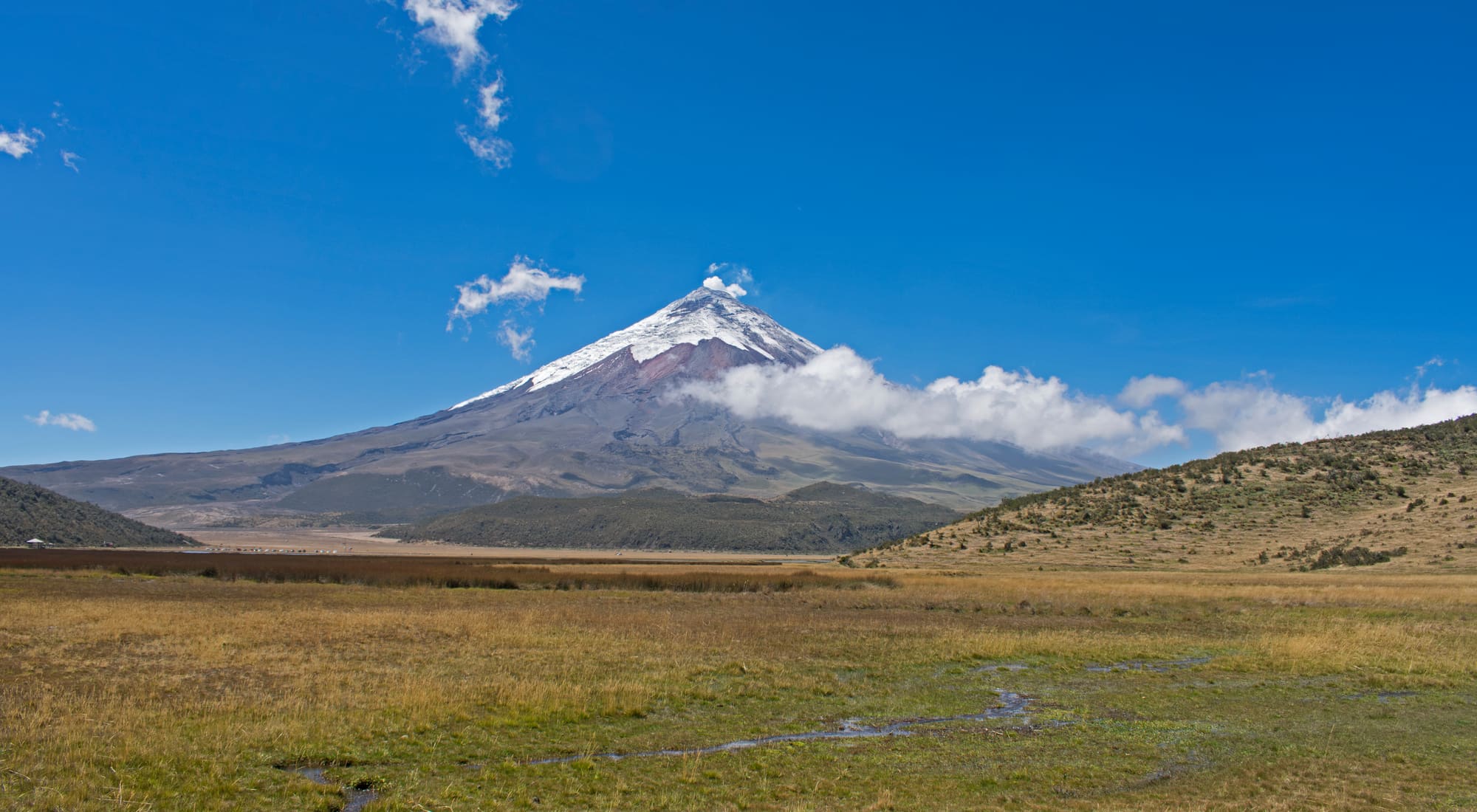 The snow-capped Cotopaxi volcano rising from the highland plain south of Quito, with clouds wrapping its flanks